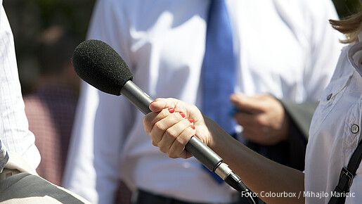 Eine Frau hält einer anderen Person ein Mikrofon hin
