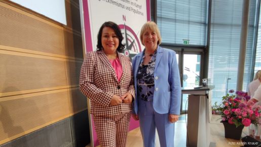 dbb Bundesfrauenvorsitzende Milanie Kreutz (links) und stellvertretende tbb Frauenvorsitzende Kerstin Knauer (rechts) auf der 19. Frauenpolitischen Fachtagung in Berlin. Zwei Frauen stehen auf einer Bühne und schauen in die Kamera