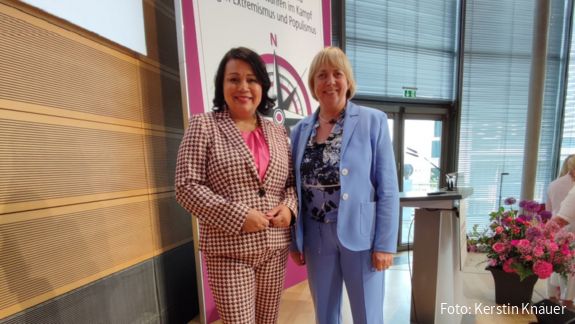 dbb Bundesfrauenvorsitzende Milanie Kreutz (links) und stellvertretende tbb Frauenvorsitzende Kerstin Knauer (rechts) auf der 19. Frauenpolitischen Fachtagung in Berlin. Zwei Frauen stehen auf einer Bühne und schauen in die Kamera