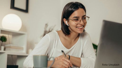Das Foto zeigt eine Frau, die im Homeoffice ist und gerade an einer Videokonferenz teilnimmt.