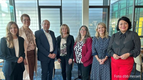 Eine Menschengruppe steht Schulter an Schulter und blickt in die Kamera.