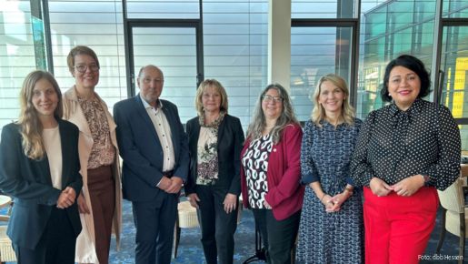 Eine Menschengruppe steht Schulter an Schulter und blickt in die Kamera.