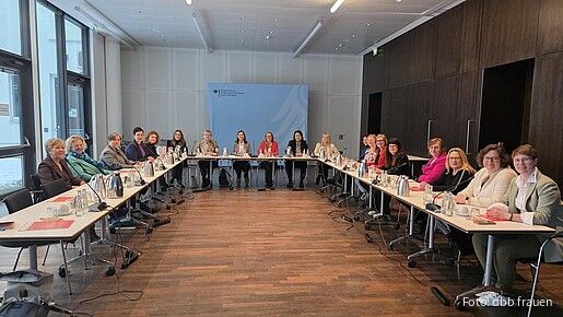 Eine Gruppe Frauen sitzt an Tischen in einem Seminarraum