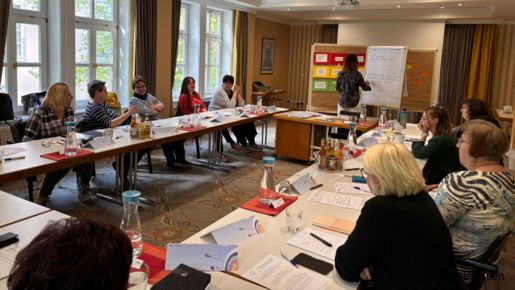 Eine Gruppe Frauen sitzt in einem Seminarraum im Tischkreis